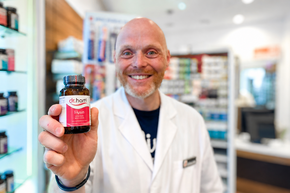 rotunden apotheke Pharmazeut hält ein Dr. Hartl Produkt in der Hand